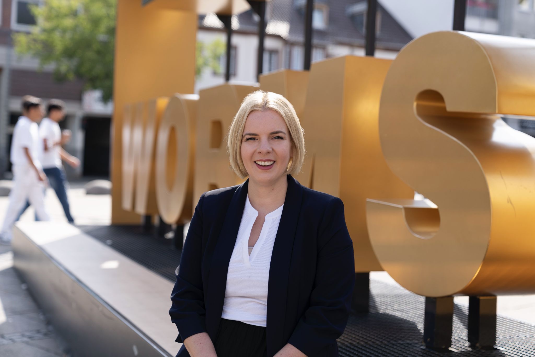 Porträt von Carolin Cloos vor dem goldenen Schriftzug Worms